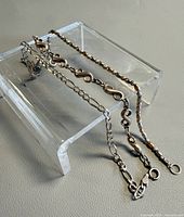Three sterling silver bracelets on acrylic stand