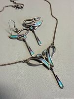 Full view of necklace and earrings showing design and enamel colouring