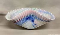 Side profile showing ribbed body and serrated rim of pastel swirl glass bowl