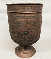 Full view of engraved copper footed urn