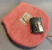 Curvo Safety pink felt heating pad with Abercrombie chrome hand warmer resting on top