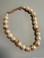 Full view of Fendi pearl choker laid flat showing pearls and gold-tone spacers