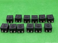 Group of twelve identical push button switches front view showing screw terminals