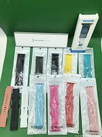 All 14 Apple Watch bands displayed: two boxed, sealed silicone bands, leather and sport styles