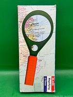 Front of retail box showing magnifying glass image and map background