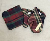 Oven mitts and stack of napkins displayed together