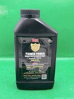 Full view of 1 L black bottle against green background