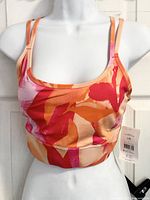 Front view of pink and orange Athletic Works strappy sports bra on mannequin with tag attached