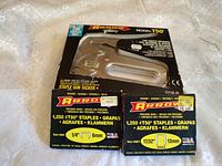 Front view of Arrow T50 staple gun in packaging with two boxes of staples