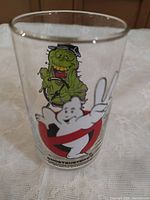 Close-up of one glass showing Slimer and peace-sign No-Ghost logo graphic