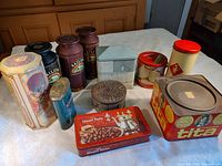 All 11 tins displayed on table, showing variety of shapes and brands