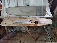 All three ironing boards displayed including the wooden folding model, tabletop board leaning, and mini board on top