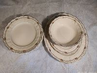 Stacked dinner plates and serving bowls showing pattern and quantity