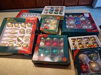 All seven boxes of multi-colour glass Christmas ornaments displayed on countertop