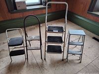 Four folding step stools in various colors and step counts