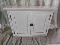 Front view of distressed white pine cabinet with closed doors