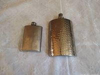Front view of both pocket flasks showing sizes and finishes
