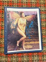 Front view of signed Drew Barrymore photograph inside blue binder