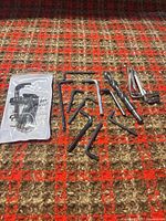 Full lot showing packaged key set, loose hex keys, two drill bits on fabric