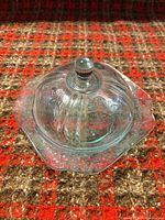 top view of covered teal pressed glass butter dish on patterned surface