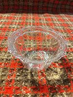 Top view of clear glass candy dish showing scalloped rim and paneled sides