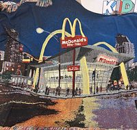 Full view of woven blanket showing McDonald’s scene and fringe