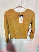 Front view of caramel waffle henley top on hanger