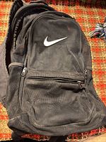 Front view showing mesh body, swoosh logo, zip pockets