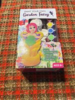 Front of sealed Paint Your Own Garden Fairy kit showing contents list and paint colors