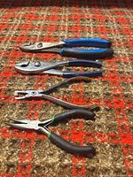 Four pliers laid out on carpet