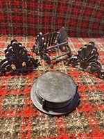 Napkin holder, two additional identical decorative ends, and stacked round coasters with holder