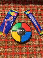 Front view of Simon game with two glow flag stick packages