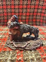 Front view of Tyr embracing Fenrir resin statue on rocky base
