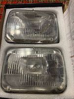Two rectangular sealed beam headlamps in foam packaging