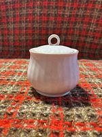 Front view of sugar bowl showing fluted body and lid with loop finial