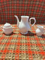 Full view of teapot, sugar bowl with lid and creamer