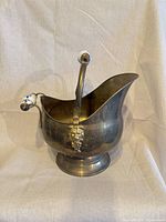 Front view showing brass body, pedestal base, and ceramic handle