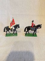 Front view of both Britains mounted figures on green bases