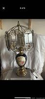 Full view of lamp showing glass panel shade, brass mounts, cobalt urn base with scene