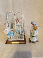 Front view of both figurines displaying size comparison and bases