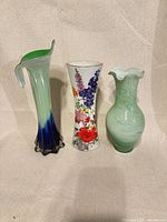 Front view of three tall vases showing colours and shapes