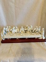 Full front view of porcelain Last Supper figurine on wood base