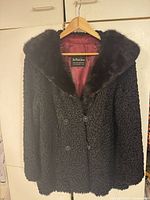 Front view of Persian lamb coat showing double-breasted buttons, mink collar, satin lining