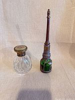 Clear and green glass perfume bottles side by side