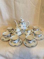 Full 15-piece porcelain tea set arranged, all items visible