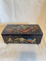 Closed black lacquer jewelry box showing painted Chinese scene