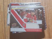 Stack of hockey cards showing Aleksander Barkov UD Game Jersey card on top