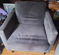 Front view of grey upholstered lounge chair showing cushions and arms