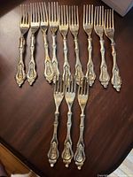 All 12 silverplate forks arranged on table