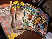 Five stacked comic books showing all titles